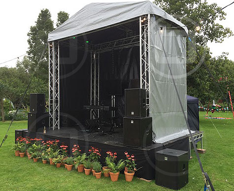 Small covered stage for private garden party.
