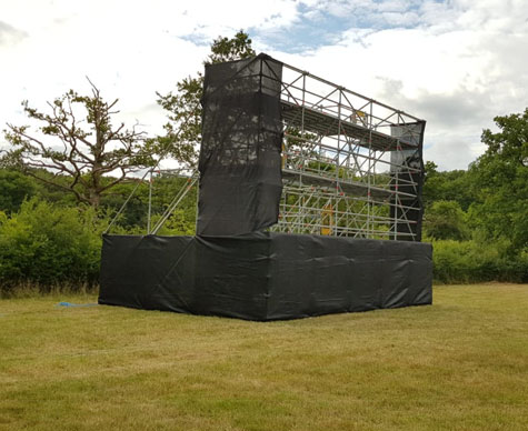 Typical Layher support structure for drive-in cinema screen on grass.